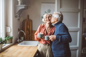 a man kisses a woman on the cheek in a kitchen