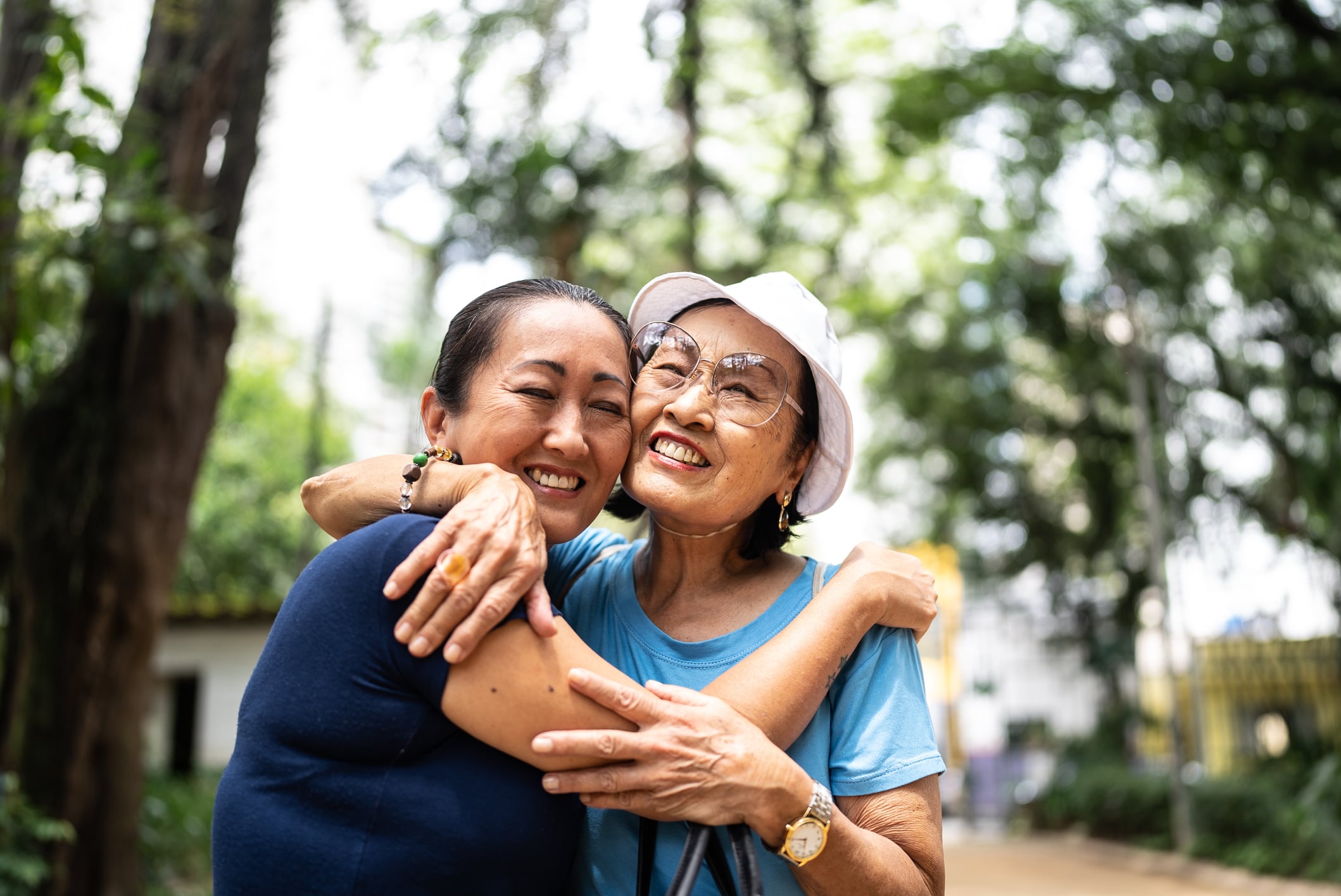 two older women hugging each other and smiling for the camera
