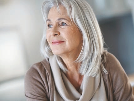 an older woman with gray hair and blue eyes is smiling