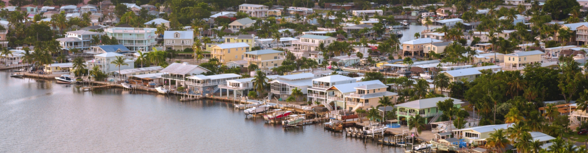 a row of houses sit on the shore of a body of water in Florida