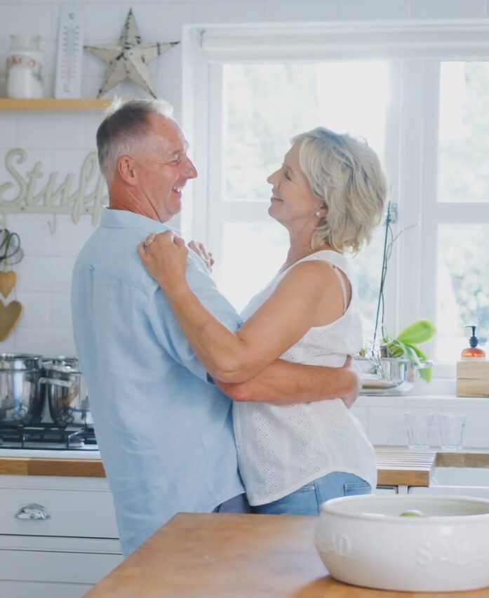 a man and woman are hugging in a kitchen